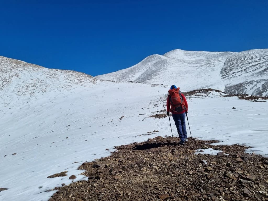 Montañista ascendiendo en terreno nevado